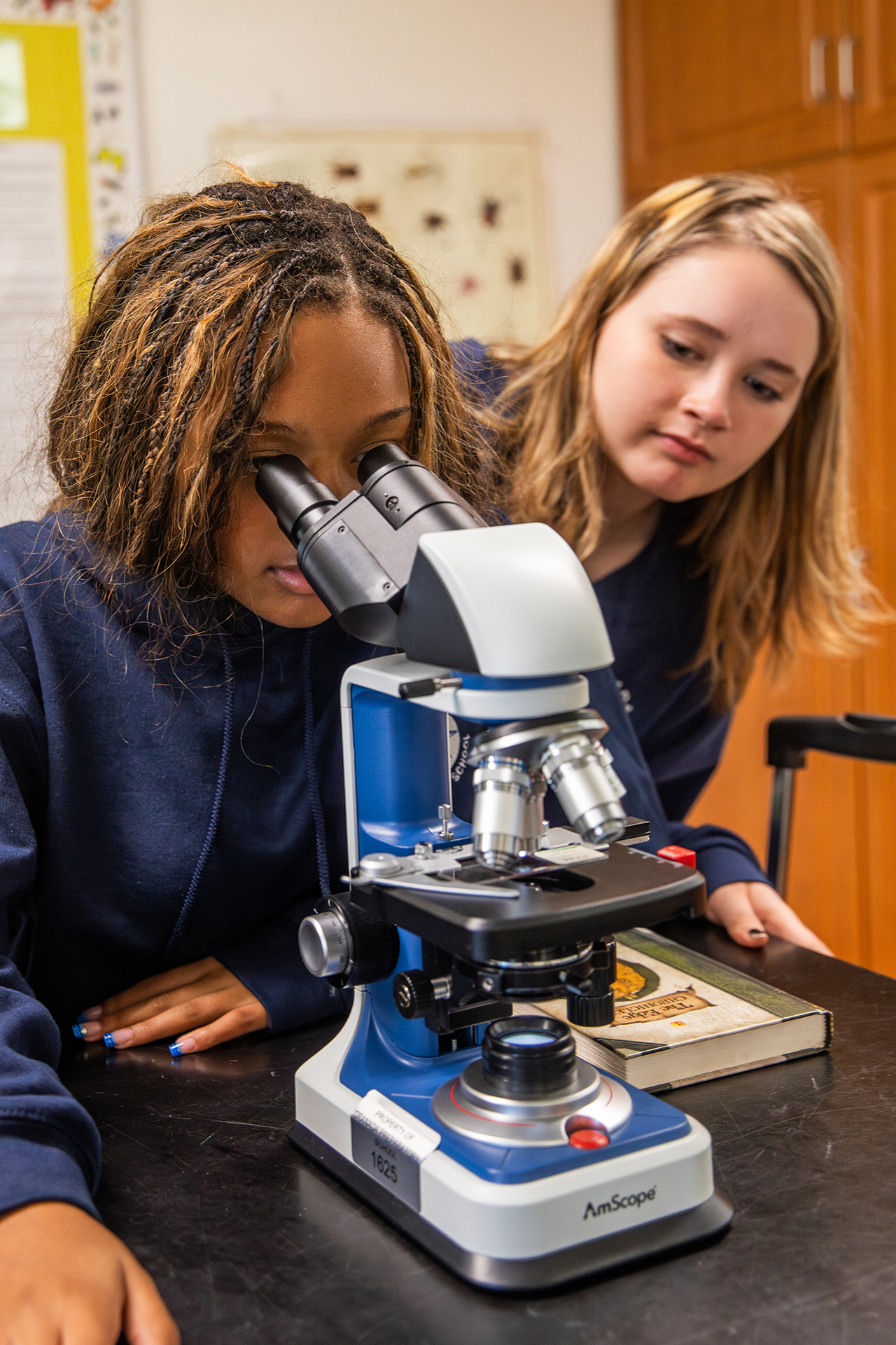 GPS student at microscope (closeup)